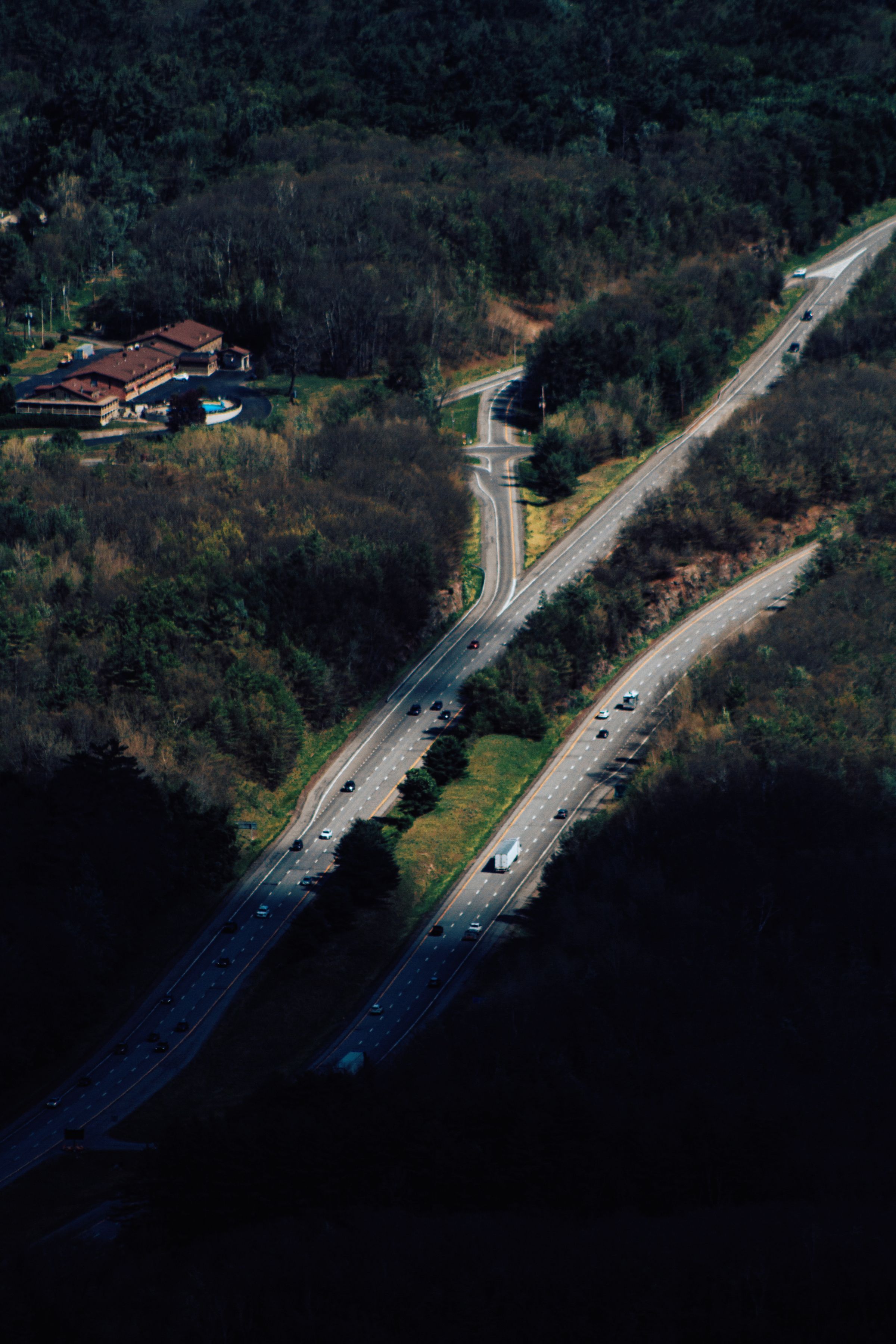 Aerial view of a divided highway running through dense forest