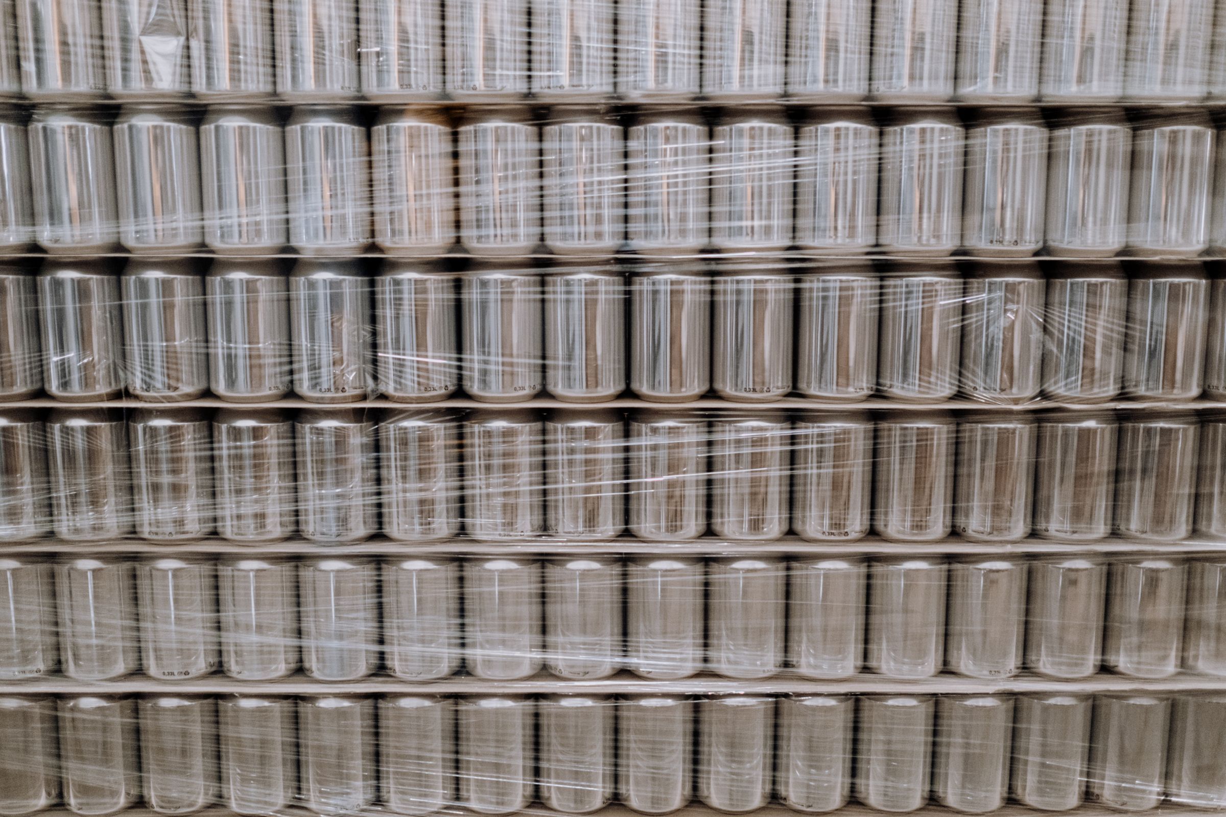 Close view of a shrink-wrapped pallet of blank cans